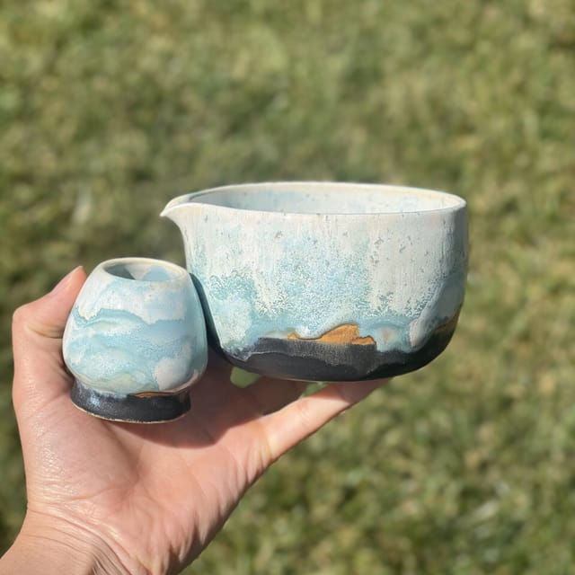 Glacier Matcha Set — A spouted matcha bowl and tiny cup in icy glacier blue over dark clay